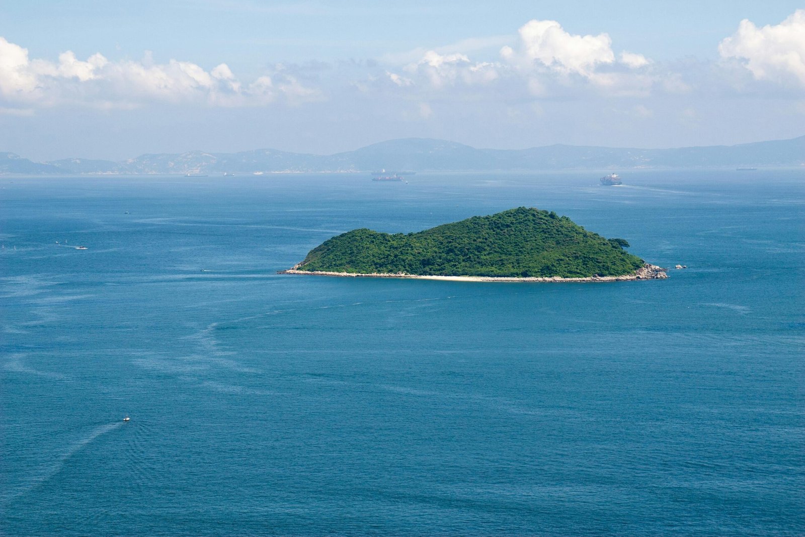 Breathtaking aerial shot of a vibrant green island surrounded by the blue sea in Hong Kong, ideal for nature and travel themes.